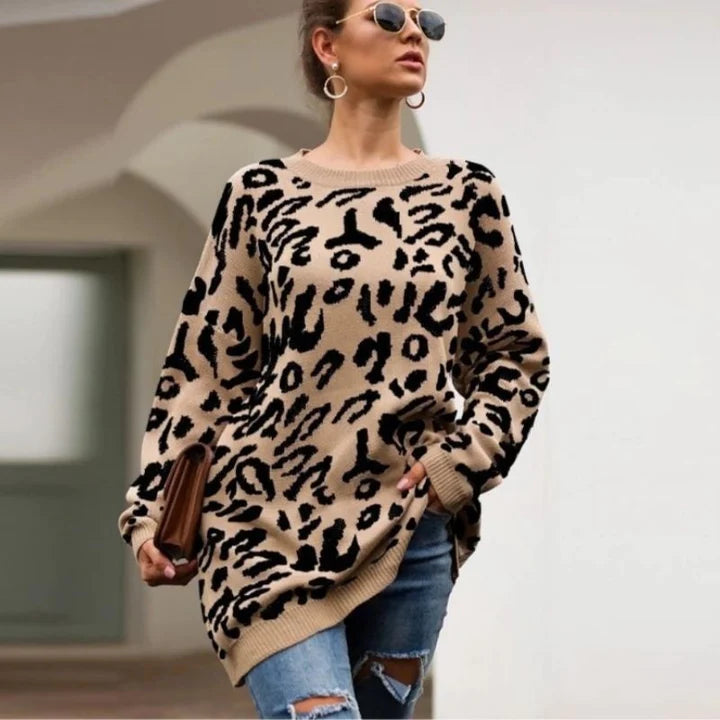 Frau in modischem Leopardenmuster-Pullover, zerrissene Jeans, Sonnenbrille, Ohrringe, hält eine Clutch. Trendige Herbstmode, urbaner Stil.