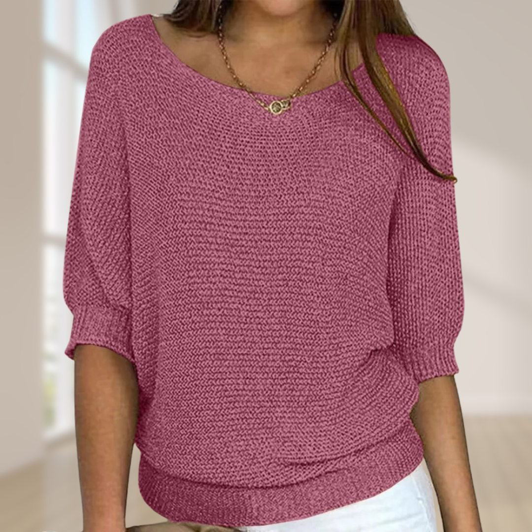 Frau trägt rosa Strickpullover mit Dreiviertelärmeln, kombiniert mit weißer Hose. Modetrend, Damenmode, lässiger Look, gemütlicher Stil.