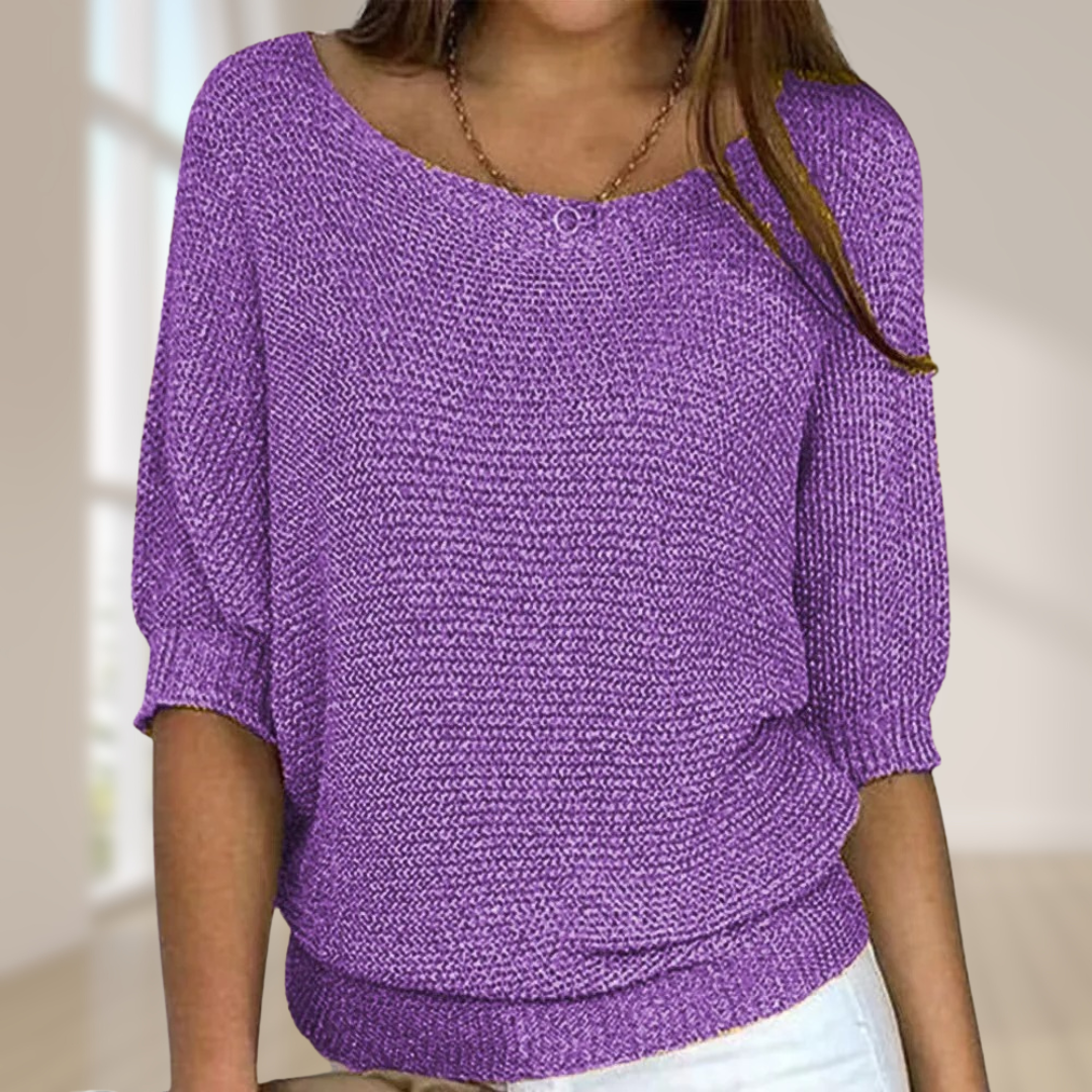 Frau trägt lila Strickpullover mit Dreiviertelärmeln, lässiger Stil. Modetrend, Damenbekleidung, gemütlicher Look, Innenaufnahme.