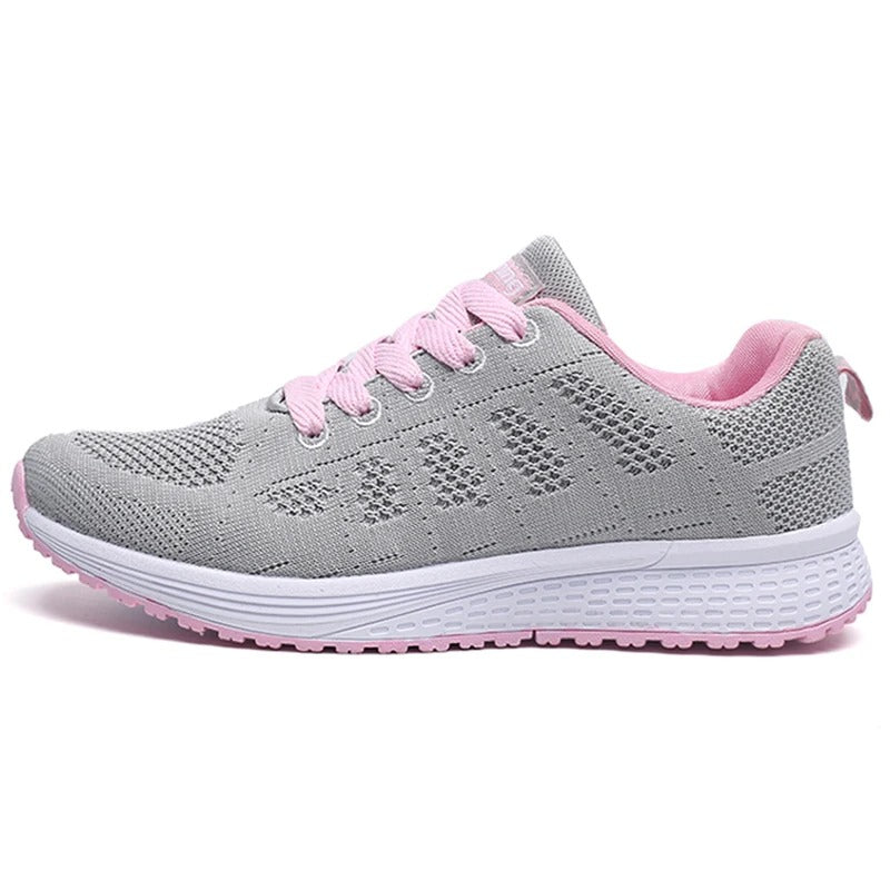 Grauer Damen-Laufschuh mit rosa Schnürsenkeln und weißer Sohle, atmungsaktives Mesh-Design, ideal für Sport und Freizeit.