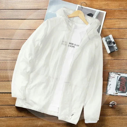 Weiße Windjacke mit Kapuze auf Holzboden, daneben eine Kamera und eine Coca-Cola-Dose. Ideal für Outdoor-Aktivitäten und Freizeitmode.