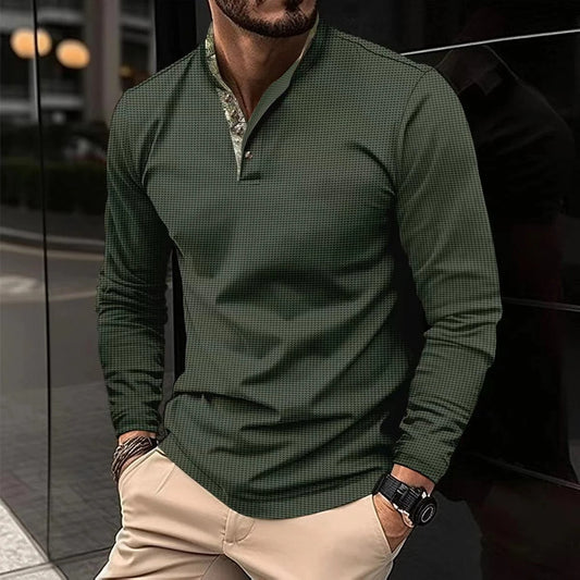 Mann in grünem, kariertem Langarmhemd und beigen Hosen lehnt an schwarzer Wand. Stilvolle Herrenmode, urbaner Look, Freizeitkleidung.