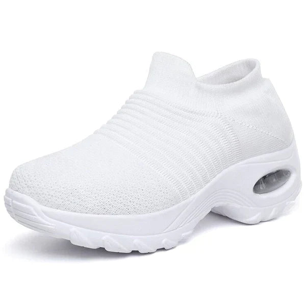 Weiße Damen-Sneaker mit atmungsaktivem Strick-Obermaterial und dicker Sohle. Bequeme, modische Schuhe für Sport und Freizeit.