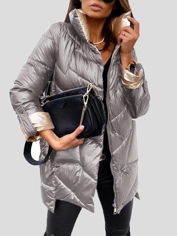 Frau in silberner Daunenjacke mit schwarzer Handtasche, modisch gekleidet. Wintermode, stilvolle Damenbekleidung, elegante Accessoires.