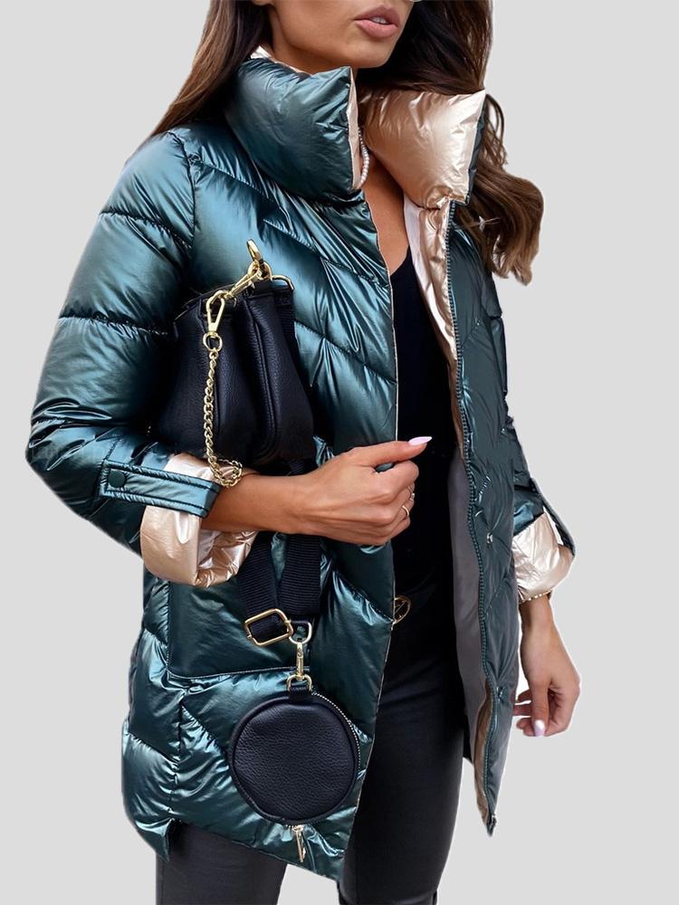 Frau in glänzendem, grünem Daunenmantel mit schwarzer Tasche. Modetrend Winterjacke, stilvolle Damenbekleidung, elegantes Design.