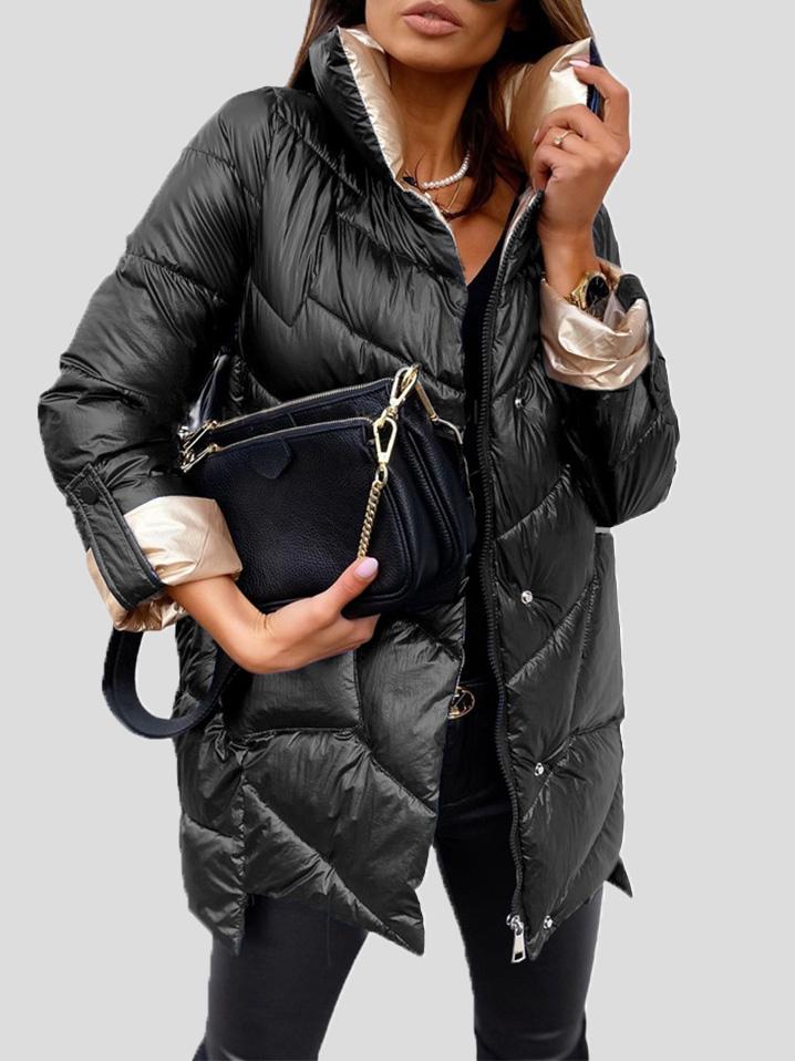 Frau in schwarzer Daunenjacke mit goldenen Details, hält schwarze Handtasche. Modetrend Winterjacke, stilvoll und elegant.